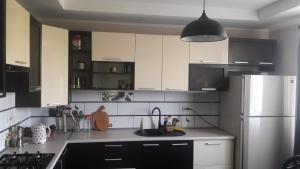 cocina con armarios blancos y nevera de acero inoxidable en Відрада en Myrhorod