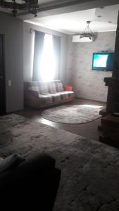 a living room with a couch and a window at Відрада in Myrhorod