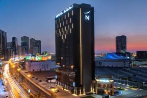 a tall building with the letter n on it in a city at Novotel Sharjah Expo Centre in Sharjah