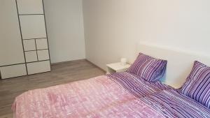 - une chambre dotée d'un lit avec des draps violets et un miroir dans l'établissement J&E NERIES Apartment, à Kaunas