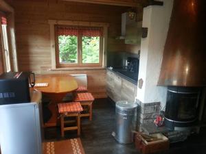 a kitchen with a table and a fireplace in a cabin at Le Valmandine in La Bresse