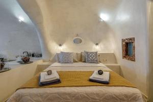 a bedroom with a large bed with towels on it at Hidden Treasure Suites in Vóthon +39 photos