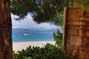 ein Segelboot im Wasser am Strand in der Unterkunft Hotel Romantica in Loutra Edipsou