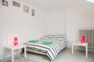 Appartement Cosy et Lumineux في تور: غرفة نوم بيضاء مع سرير وطاولتين