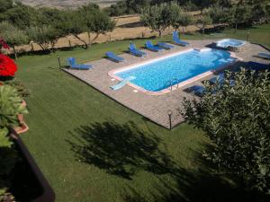 an overhead view of a swimming pool with blue chairs at Agriturismo Francadu in Santu Lussurgiu