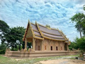 Smile Resort في Ban Phai Cham Sin: مبنى صغير مع سقف في حديقة