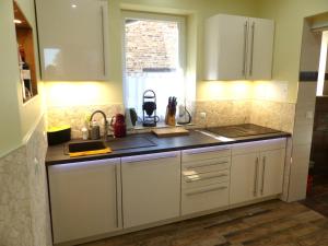 a kitchen with white cabinets and a window at Ferienwohnung Stadtoase in Wittenberg in Lutherstadt Wittenberg