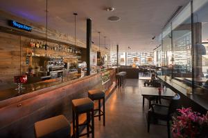 a restaurant with a bar and some tables and chairs at Residence Zur Post Sexten in Sesto
