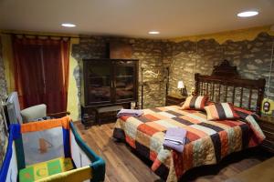 a bedroom with a bed and a rock wall at Casa Rural Cal Parines in Vilabella