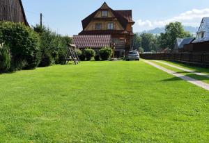 duży dziedziniec przed dużym domem w obiekcie Apartamenty u Krysi w mieście Witów