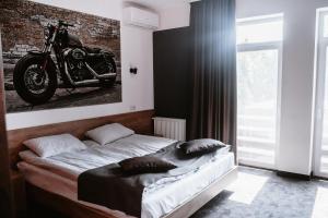 Clubhouse في ايفانو - فرانكيفسك: غرفة نوم مع سرير مع دراجة نارية على الحائط
