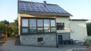 ein Haus mit einem Dach mit Sonnenkollektoren darauf in der Unterkunft Ferienwohnung Tine in Oberhausen