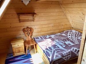 sypialnia z łóżkiem w chacie z bali w obiekcie Apartamenty u Krysi w mieście Witów