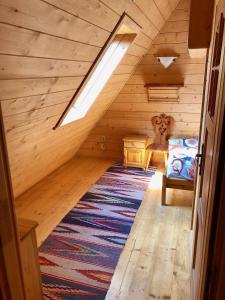 a attic room with a bed and a rug at Apartamenty u Krysi in Witów