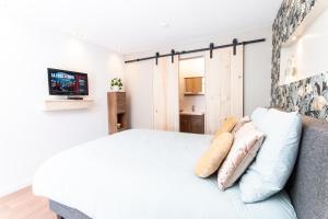 1 dormitorio con 1 cama y TV en la pared en Eindhoven Inn, en Eindhoven