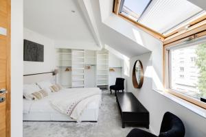 - une chambre avec un lit blanc et une fenêtre dans l'établissement NOCNOC - Villa Paradis, piscine et rooftop au coeur de Nantes, à Nantes