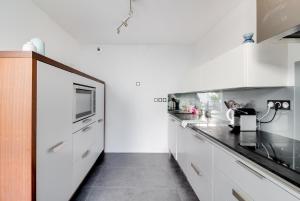 a kitchen with white cabinets and black counter tops at NOCNOC - Villa Paradis, piscine et rooftop au coeur de Nantes in Nantes