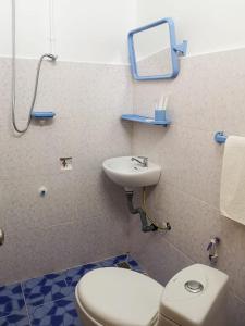 La salle de bains est pourvue de toilettes et d'un lavabo. dans l'établissement Route 76 Guest House, à Saen Monourom