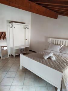 a white bedroom with a white bed and a white cabinet at Carducci 49 in Mantova