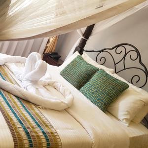 a bed with towels and pillows on it at Margarita House in Nairobi