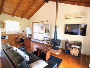 a living room with a couch and a stove at Pencil Creek Cottages in Mapleton