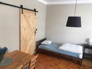 a room with a bed with a door and a table at Domek przy Rajskiej in Jerzmanowice