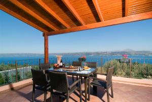 - une table et des chaises sur une terrasse avec vue sur l'océan dans l'établissement Villa Amalia, à Megála Khoráfia