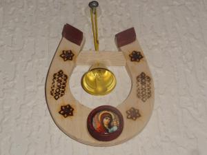 a wooden clock with a picture of a man on it at Sia Rebir D, Hotel Rebir in Daugavpils