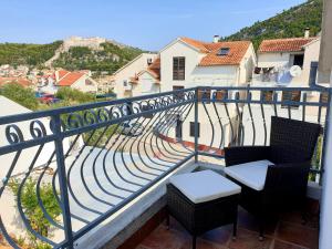 a balcony with two chairs and a view of a street at Villa Sandra Hvar in Hvar