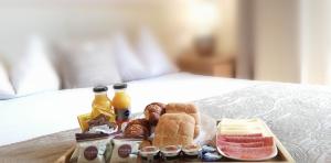 a tray of food with pastries and drinks on a bed at SAN MARCO3 Apartment in Venice