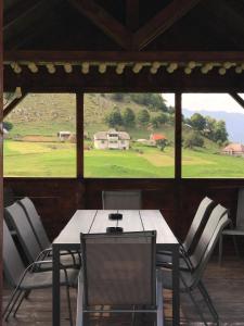 une salle à manger avec une table, des chaises et une grande fenêtre dans l'établissement Casa Sisif, à Fundata