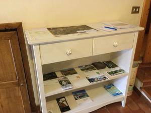 Una cómoda blanca con libros. en Agriturismo Crodi, en Miane