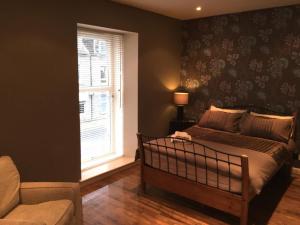 1 dormitorio con cama y ventana en Pineapple Apartments en Aberdeen