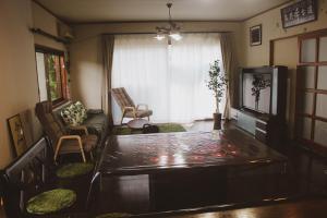 - un salon avec une table et un canapé dans l'établissement Guesthouse Yui, à Hongu