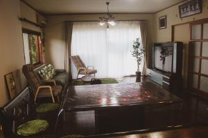 Guesthouse Yui في هونغو: غرفة معيشة مع طاولة وأريكة