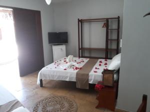 a bedroom with a bed with roses on it at Pousada Porto Azul in Cumbuco +22 photos