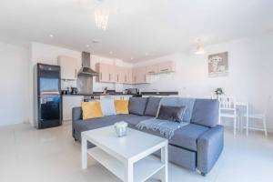 - un salon avec un canapé bleu et une table blanche dans l'établissement The Penthouse @ Waterside Grange, à Slough