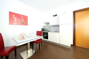 una piccola cucina con tavolo e sedie rosse di Casa Turati a Bari