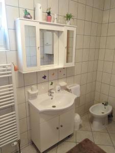 a white bathroom with a sink and a toilet at Apartmani MARIN-ŽUPANJA in Županja +62 photos