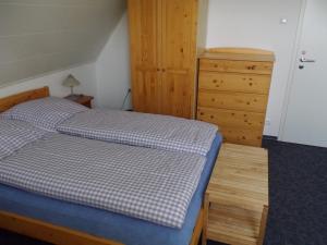 1 dormitorio con cama y tocador de madera en Ferienwohnung Fritzke, en Lemförde