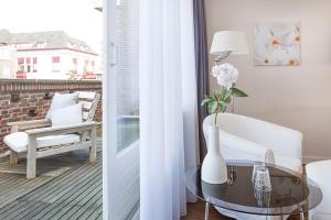 ein Wohnzimmer mit einem Tisch und einer Vase mit einer Blume in der Unterkunft Hotel Gevers in Scheveningen