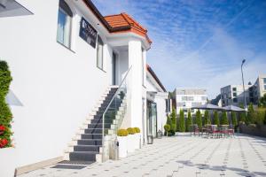 a white building with stairs and tables and chairs at Hudson in Koszalin