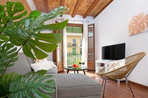 ein Wohnzimmer mit einem Sofa und einem TV in der Unterkunft Stay U-nique Apartments Girona in Barcelona