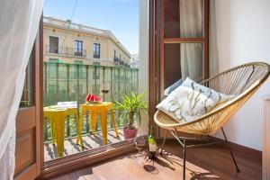 einen Balkon mit einem Stuhl und Blick auf ein Gebäude in der Unterkunft Stay U-nique Apartments Girona in Barcelona