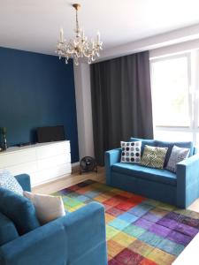 a living room with two blue couches and a colorful rug at Apartament Pruszków in Pruszków