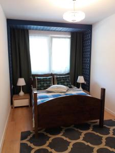 a bedroom with a large bed with a blue headboard at Apartament Pruszków in Pruszków