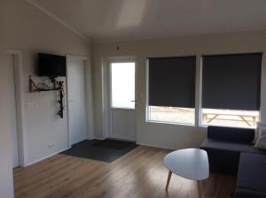 a living room with a couch and two large windows at Hvammstangi Hill Homes in Hvammstangi