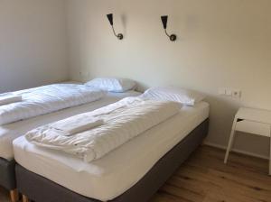クヴァンムスタンギにあるHvammstangi Hill Homesのベッド2台が隣同士に設置された部屋です。