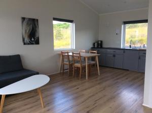 a living room with a table and chairs and a kitchen at Hvammstangi Hill Homes in Hvammstangi