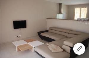 uma sala de estar com um sofá e uma televisão de ecrã plano em Les Dentelles de Montmirail em Carpentras